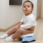 stubborn toddler looking at camera during potty training