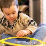 toddler boy playing with his toy car ramp